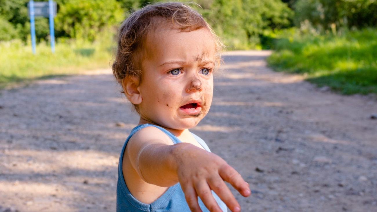 surprised-little-boy-is-squatting-on-the-grass-bo-2024-12-04-22-21-06-utc